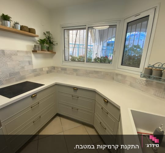 מטבח משופץ עם אריחים דקורטיביים ומשטח עבודה חדש